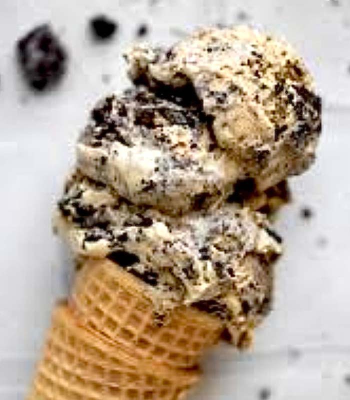 A waffle cone filled with two scoops of cookies and cream ice cream, with visible chunks of chocolate cookies mixed into the creamy vanilla base—a sweet treat you’ll love after a meal at your favorite Gatesville Restaurant.
