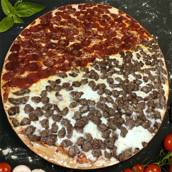 A large pizza divided in half, with one side topped with pepperoni and the other with sausage, sits on a dark surface surrounded by basil, garlic, and tomatoes—fresh from a top Pizza Restaurant in Gatesville TX.